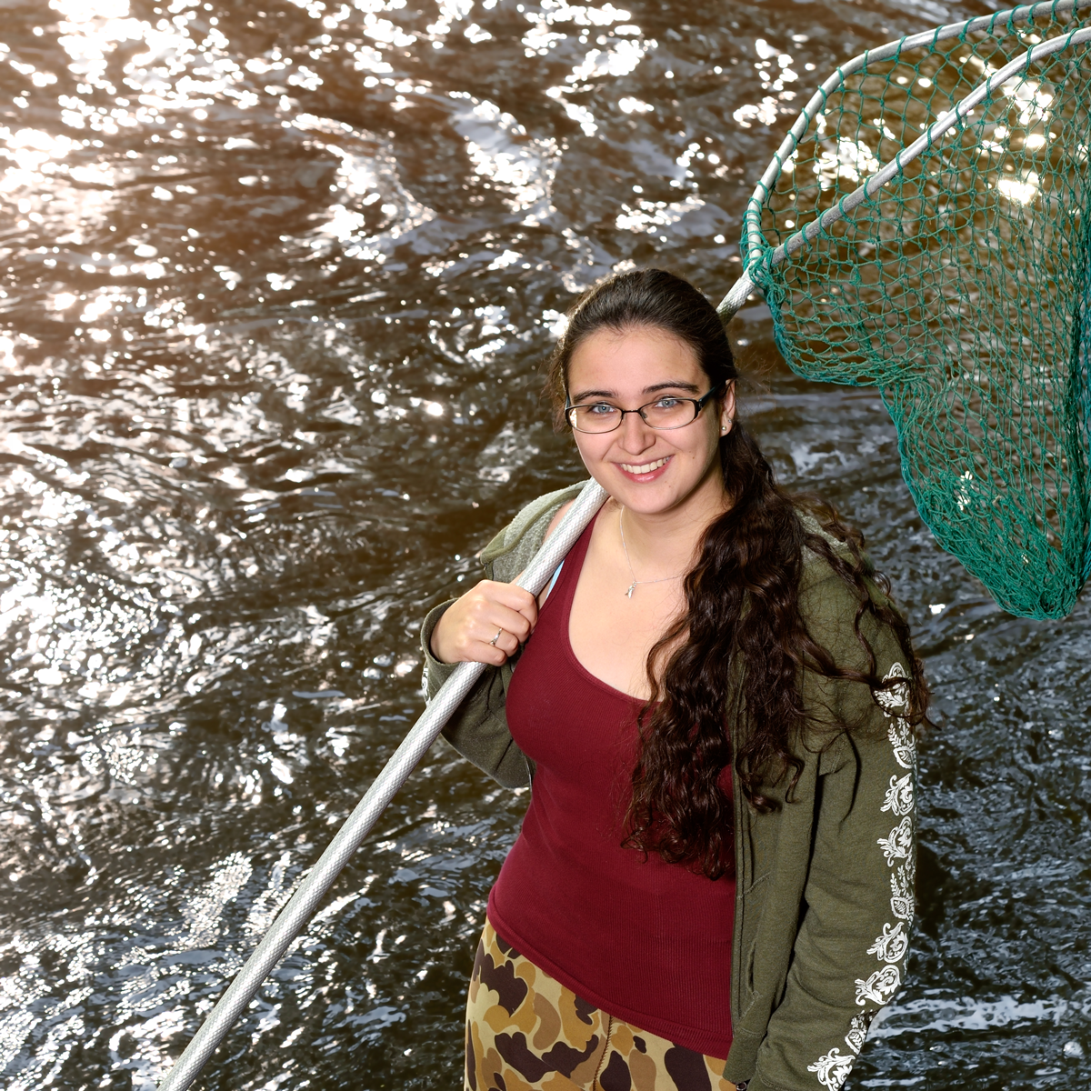Clara Lepard standing in a body of water holding a net.